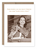 The image features a sepia-toned photograph of a smiling woman holding a cocktail shaker, set against a retro bar backdrop. Above her is the text: "Some people call me crazy. I prefer the term happy with a twist." This vintage photo-style birthday card comes from Shannon Martin Design and is printed on recycled paper.