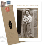 The Do No Harm Birthday Card by Shannon Martin Design showcases a sepia-toned woman cowboy in front of a rustic building with the phrase "Do no harm, but take no crap." Includes envelope and vintage stamps.