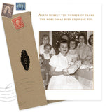 The Enjoying You Birthday Card by Shannon Martin Design features a sepia photo of a smiling woman with children holding a gift. Made in the USA from recycled paper, it reads: Age is merely the number of years the world has been enjoying you.