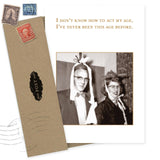 The Act My Age Birthday Card by Shannon Martin Design features a vintage black and white photo of a smiling man and woman in party hats with streamers. The card reads, "I don’t know how to act my age, I’ve never been this age before.