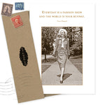 The Fashion Show Birthday Card by Shannon Martin Design features a sepia photo of a stylish woman outdoors with Coco Chanel’s quote: "Everyday is a fashion show and the world is your runway." Includes a brown envelope with stamps. Made in the USA.