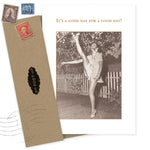 The "It's A Good Day Birthday Card" by Shannon Martin Design features a sepia photo of a woman high kicking by a picket fence, paired with a brown recycled envelope. The card reads, "IT'S A GOOD DAY FOR A GOOD DAY!"—ideal for vintage photo lovers.