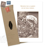 The Garden Get Well Card by Shannon Martin Design features a sepia photo of a girl in a patterned dress with flowers and the message "Sending you a garden of get well wishes," perfect for heartfelt notes. Includes classic envelope with stamps.