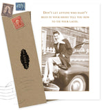 The Tie Your Laces What A Hoot Card by Shannon Martin Design features a sepia photo of a smiling woman on a vintage car with the phrase, “Don’t let anyone who hasn’t been in your shoes tell you how to tie your laces,” and comes with a brown envelope.