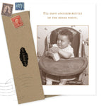 The "Another Bottle Baby Card" by Shannon Martin Design features a sepia vintage photo of a smiling baby in a high chair with the caption, “I’ll have another bottle of the house white,” plus a brown envelope with vintage stamps and a black “POST” label.