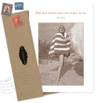 The Sun Shines Birthday Card by Shannon Martin Design features a smiling woman in a striped towel on the beach, with the quote, "The sun shines not on us but in us. - John Muir." Includes envelope; card is made with recycled paper.