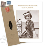 The "Rude, You're Younger Than Me Birthday Card" by Shannon Martin Design features a smiling woman in a retro dress and hat on recycled paper, with the cheeky quote, "Rude that you're younger than me, but ok." Includes a brown envelope.