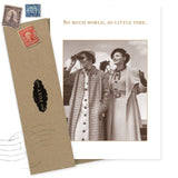 The World Birthday Card by Shannon Martin Design features a sepia photo of two women in coats, one with binoculars, and the words "So much world, so little time." Made in the USA, it includes an envelope with vintage postage stamps.