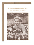 The Full Heart Thank You Card by Shannon Martin Design is a vintage-style card printed on recycled paper, showcasing a smiling woman in a headscarf surrounded by flowers. She holds a basket with the text above reading, "If you think my hands are full, you should see my heart." It includes a charming Kraft envelope for an added nostalgic touch.