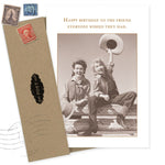 The Hats Off Birthday Card by Shannon Martin Design features a sepia photo of two women in western outfits on a fence, smiling and waving hats. Made in the USA, it reads: Happy birthday to the friend everyone wishes they had.