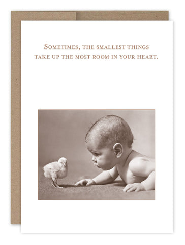 The Room In Your Heart New Baby Card by Shannon Martin Design is crafted from recycled paper and features a sepia-toned vintage photo of a baby on its stomach, curiously looking at a chick, with the text: Sometimes, the smallest things take up the most room in your heart.