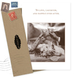 The Happily Ever After Wedding Card by Shannon Martin Design features a sepia-toned image of two people toasting with champagne glasses and the message, “To love, laughter, and happily ever after.” Includes envelope. Made in USA.