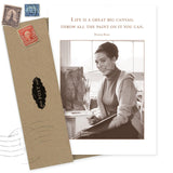 Shannon Martin Design's Big Canvas Birthday Card features a sepia photo of a smiling woman with paintbrushes by a canvas. Includes the quote: “Life is a great big canvas; throw all the paint on it you can.” Envelope with vintage stamps, recycled paper.
