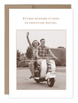 The Adventure Waiting Birthday Card by Shannon Martin Design features a sepia image of a smiling couple on a vintage scooter. The woman waves happily as the man steers, with the text above: Its bad manners to keep an adventure waiting.