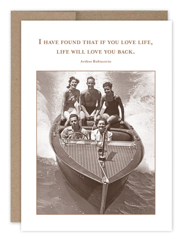 Five friends smile and ride in a small wooden speedboat in this vintage-style image on the If You Love Life Birthday Card by Shannon Martin Design, featuring the quote: “I have found that if you love life, life will love you back. – Arthur Rubinstein.”.