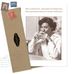 The Roosters Birthday Card by Shannon Martin Design features a sepia image of a woman at a table with the caption: “The older I get, the more I understand why roosters scream to start their day.” Includes envelope with vintage stamps.