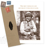 The Shannon Martin Design “Best Things In Life Birthday Card” features a sepia image of a smiling person in vintage attire holding three puppies, with the text, “The best things in life are meant to be held close.” Includes brown envelope.
