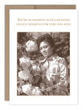 The Blossoming Birthday Card by Shannon Martin Design is a vintage USA-made card featuring a sepia-toned woman in a patterned dress with hydrangeas and the message: "You're blossoming with a richness usually reserved for very fine wine.