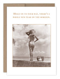 A vintage-style photo shows a woman in swimsuit and sun hat by the sea. Text: "Hold on to your hat, there’s a whole new year on the horizon." Hold On To Your Hat Birthday Card by Shannon Martin Design—made in USA.