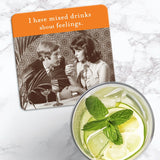 The Shannon Martin Design "Mixed Drink Feelings Coaster" features a vintage man and woman with cocktails and the caption "I have mixed drinks about feelings"—a stylish, heat-resistant retro accent for any marble tabletop.