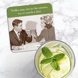 The Worth A Shot Coaster by Shannon Martin Design features a vintage photo of a smiling couple toasting, with the phrase "Vodka may not be the answer, but it’s worth a shot." Shown next to a lime and mint cocktail on marble.