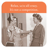 Two women in retro outfits smile and chat indoors. The "We're All Crazy Coaster" by Shannon Martin Design features the phrase "Relax, we're all crazy. It's not a competition," with an orange background—makes a fun hostess gift.