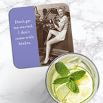 The Don't Get Started Coaster by Shannon Martin Design features a vintage photo of a smiling woman in a polka-dot outfit in a car with the quote "Don't get me started. I don't come with brakes." Cork-backed and heat/water resistant.