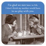 Two women from the 1960s smile and chat at a café, one holding a cake slice on Glad We Met Coasters. Captioned humorously about their reunion and mothers disapproval, its an ideal quirky hostess gift by Shannon Martin Design.