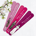 Four pink and purple double-sided Confidence Emery Boards by Shannon Martin Design, featuring vintage women’s photos and motivational quotes, are stylishly arranged beside white blooms—a chic manicure tool for every beauty routine.
