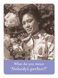 In a sepia-toned image, a woman in a patterned blouse stands beside blooming flowers, looking at the camera. The text reads What do you mean Nobodys perfect?‚Äîa playful nod to lifes imperfections by Shannon Martin Design and featured on the Nobodys Perfect Magnet.