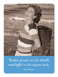 A woman stands joyfully by a wooden post on the beach, embodying carefree spirit in her striped shirt and shorts. Like a Sunlight Magnet from Shannon Martin Design, she captures unexpected joy beside fridges or amidst sea breezes—true sunlight to the square inch. Walt Whitman quote follows.