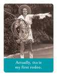 A joyful woman in cowboy attire spins a lasso near lockers in this black and white image. The bottom text humorously declares, Actually, this is my first rodeo. From the Sunlight Magnet collection by Shannon Martin Design.