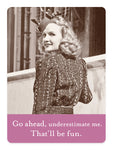 A woman in vintage attire, wearing a patterned dress and small hat, stands by a cabinet-like railing, smiling over her shoulder. Featuring the caption on the Go Ahead Magnet from Shannon Martin Design: Go ahead, underestimate me. Thatll be fun.