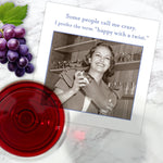 The Happy With A Twist Napkin by Shannon Martin Design features a vintage photo of a smiling woman with a cocktail mixer, set on marble alongside grapes and red wine. The caption reads, "Some people call me crazy. I prefer the term happy with a twist.