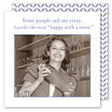 A smiling woman in vintage attire shakes a cocktail shaker behind the bar next to a stack of "Happy With A Twist Napkin" by Shannon Martin Design. Text above: Some people call me crazy. I prefer the term happy with a twist. Blue and white patterned border.