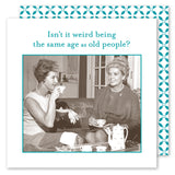 Two vintage characters sit on a couch, smiling and drinking tea beside Shannon Martin Design's Same Age Napkin. Text above reads: "Isn’t it weird being the same age as old people?" A teapot sits on the table with biodegradable napkins.