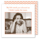 A woman sits at her kitchen table, looking disappointed with her head in her hands. Next to her is the whimsical Life Coach Napkin by Shannon Martin Design. Above reads: My life coach just informed me I didn’t make the team.