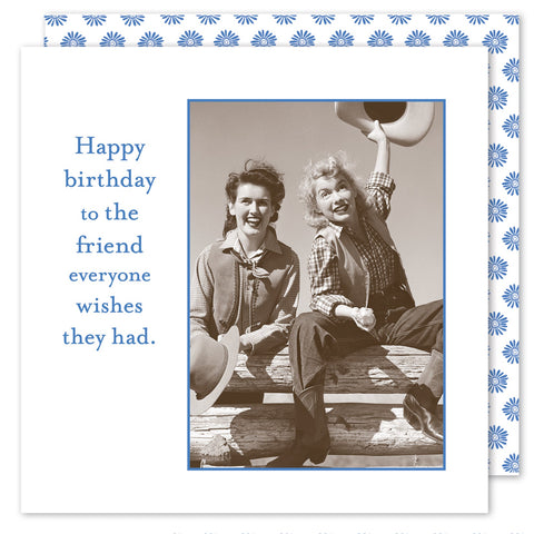 The sepia-toned photo on the Hats Off Beverage Napkin by Shannon Martin Design features two smiling people on a wooden railing with hats, framed by a daisy-patterned border reminiscent of FSC-certified tissue designs. The text reads, Happy birthday to the friend everyone wishes they had.