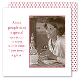 A woman in formal attire smiles, holding a glass of wine at a checkered table with Shannon Martin Design's Special Occasion Napkin beside her. A decanter sits nearby. Text reads: Some people need a special occasion to enjoy wine—I just need a glass.