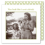 Three women outdoors; one drinks near Shannon Martin Design’s "I Need A Drink Napkin"—text reads, You look like I need a drink.