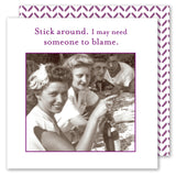 Four people sit at an outdoor table with vintage napkins by Shannon Martin Design. A purple border surrounds the image, with text above: “Stick around. I may need someone to blame.” Patterned background shown. Product: Stick Around Napkin.