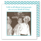 Three adults in balloon hats and costumes laugh together, toasting with Shannon Martin Design's "Kind Of Crazy Napkin" on the table. Caption: Life is all about finding people who are your kind of crazy.