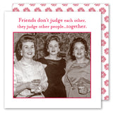 Three smiling women in vintage outfits hold drinks and Friends Don't Judge Napkins by Shannon Martin Design. Above them, it reads: Friends don’t judge each other, they judge other people… together. A floral background completes the scene.