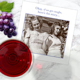 The If We Get Caught Napkin by Shannon Martin Design features a vintage photo of two smiling women with the text, "Okay, if we get caught, here’s the story..." alongside a glass of red wine and purple grapes.