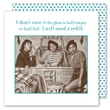 Three women at a vintage bar hold Glass Half Full Napkins from Shannon Martin Design. Card text above: “I don’t care if the glass is half empty or half full. I still need a refill.” Teal polka dot background.