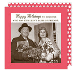 A vintage photo of a smiling couple in winter attire holding gifts, with "Happy Holidays to someone who has excellent taste in friends" above. Features festive party napkins from the Excellent Taste Holiday Napkin by Shannon Martin Design.