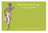 A woman with a vintage flair poses confidently against a green backdrop, holding a handbag. The text reads, "Bad vibes don‚Äö√Ñ√∂‚àö√ë‚àö¬•t go with my outfit." Crafted with humor and flair, this design from Shannon Martin Design is proudly made in the USA. ¬¨¬®¬¨¬©2022 Shannon Martin Design.