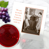 The So Much Fun Napkin by Shannon Martin Design is shown on a marble surface with grapes, biodegradable napkins, a glass of red wine, and a card featuring two women dancing and the caption, "We are so much fun that I want to be friends with us.