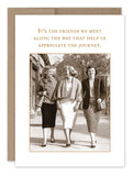 A vintage photo captures three smiling women walking together in stylish attire, exuding timeless charm, accompanied by the text, "It's the friends we meet along the way that help us appreciate the journey," a sentiment found on the Friends We Meet Friendship Card by Shannon Martin Design.