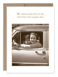 A sepia-toned image of a person smiling from the driver‚Äôs seat of a vehicle, evoking the charm of vintage photos. Crafted on recycled paper, the Karma Bus Birthday Card by Shannon Martin Design features text at the top that reads, "My dream job would be driving the karma bus.